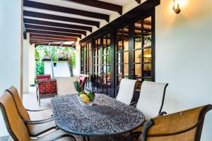 a dining room with a table and chairs on a patio at Villa Estrella del Mar in Tamarindo