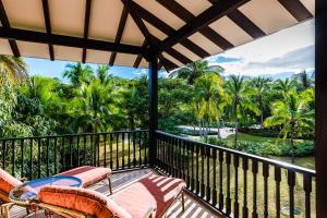 uma varanda com vista para o oceano e para as palmeiras em Villa Estrella del Mar em Tamarindo