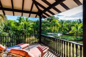 a balcony with a view of the ocean and palm trees at Villa Estrella del Mar in Tamarindo
