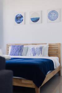 ein Bett mit blauen und weißen Kissen darauf in der Unterkunft MUJI B&W Studio - Seaview at 218 Tropicana NEAR Komtar Food Heaven with Netflix & TV Box in George Town