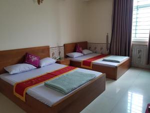 2 camas en una habitación con ventana en Khách Sạn Hương Sơn, en Bắc Giang