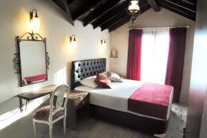 1 dormitorio con cama, espejo y silla en Villa Dreams, en Selçuk