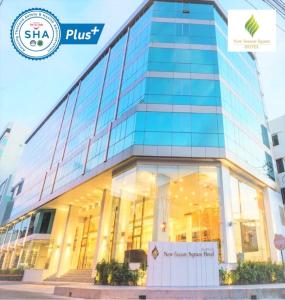 New Season Square Hotel - SHA Plus في هات ياي: مبنى زجاجي امامه لافته