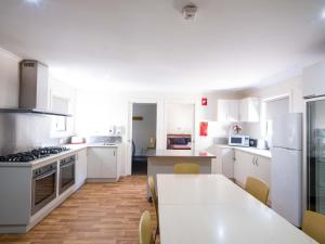 a kitchen with white cabinets and a table with chairs at Tahune AirWalk Cabin and Lodge in Geeveston