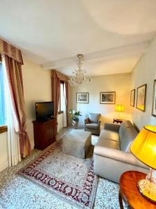 ヴェネツィアにあるSan Gregorio Venice Apartmentsのソファとテレビのあるリビングルーム