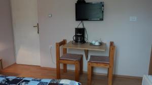 une petite table avec deux chaises et une télévision murale dans l'établissement Bed and Breakfast BLUE in BLUE, Room GREEN +, à Komiža