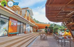 a patio of a building with tables and chairs at Green Bay Samed Resort - SHA Extra Plus Certified in Ko Samed