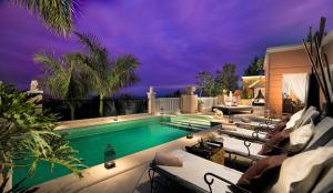 a swimming pool with lounge chairs next to a house at Royal Garden Villas, Luxury Hotel in Adeje +37 photos