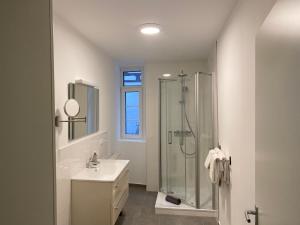 een witte badkamer met een douche en een wastafel bij Altstadt Fereienwohnung Hameln in Hameln