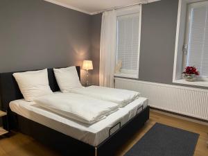 Schlafzimmer mit einem Bett mit weißer Bettwäsche und einem Fenster in der Unterkunft Altstadt Fereienwohnung Hameln in Hameln