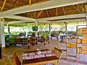 un restaurante con mesas y sillas en una habitación en Watamu Eco Villas en Watamu