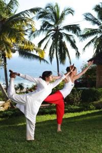 a man and a woman doing a yoga pose at Soma Manaltheeram Ayurveda BeachVillage in Kovalam