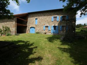 un edificio de piedra con puertas azules y un patio de césped en Gîte Lapte, 4 pièces, 6 personnes - FR-1-582-147 en Lapte