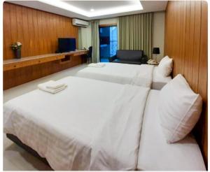 a large white bed in a hotel room at Private wooden style studio room in city area in Chiang Mai