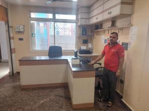 a man standing at a desk in an office at Anant Home Stay in Shillong