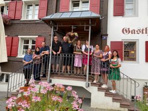 un groupe de personnes debout sur un balcon d'une maison dans l'établissement Gasthaus Rössle, à Nenzing