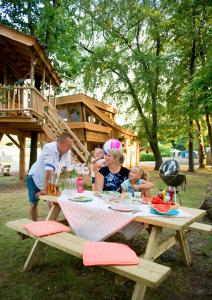 Un groupe de personnes assis à une table de pique-nique dans l'établissement Recreatiepark d'n Mastendol luxe Boomhutten, à Rijen