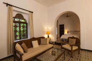 a living room with a couch and a bed at Marbella Guest House in Sinquerim