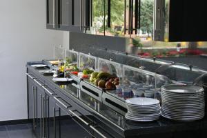 a buffet line in a restaurant with plates and food at Hotel am Rosenplatz,24 Stunden Check in, Küche, kostenfreie Parkplätze in Brechtorf