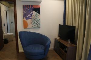 a living room with a blue chair and a television at FILEO ELEGANT LIVING in Veria