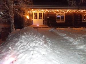 a house with christmas lights in the snow at A room (or 2 or 3) in a Lapland House of Dreams in Rovaniemi