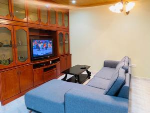 a living room with a blue couch and a tv at 100 Oastel coLiving in Tanah Rata