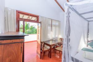 希克杜沃Villa Guru Hikkaduwa的有桌子和窗户的餐厅
