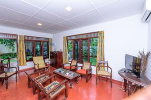 un soggiorno arredato con TV a schermo piatto di Villa Guru Hikkaduwa a Hikkaduwa