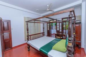 una camera con letto a baldacchino in legno di Villa Guru Hikkaduwa a Hikkaduwa