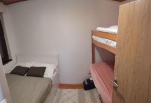 a small room with two bunk beds and a door at Jahorina apartman Košuta D5 in Jahorina