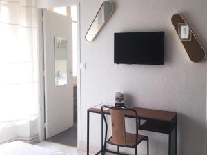 a room with a table and a television on a wall at Brit Hotel Dijon Centre Gare in Dijon
