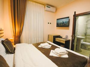 a hotel room with a bed with towels on it at Rayyan Hotel Bukhara in Bukhara