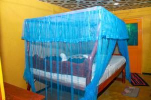 a bed in a room with a blue net at Relax Nature Villa in Sigiriya