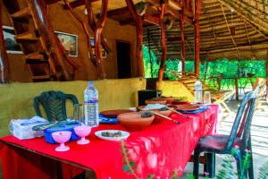 a table with a red table cloth and drinks on it at Relax Nature Villa in Sigiriya