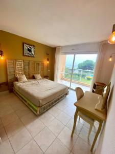 a bedroom with a bed and a desk and a window at AJACCIO les iles sanguinaires in Ajaccio