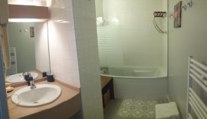 a bathroom with a sink and a tub and a shower at Appartement les gouverneurs in Saint-Martin-de-Ré