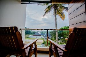 a view of a palm tree from the window of a house at Cliff Way Apartments in Varkala