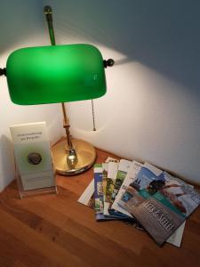 a green lamp sitting on top of a table with magazines at Apartment B311 mit Pool in Lahnstein