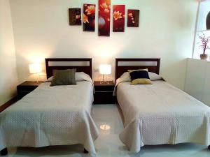 two beds sitting next to each other in a bedroom at MS Residence Building in Lucban