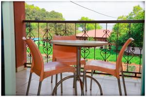 a table and four chairs on a balcony with a view at THE CROFT HOUSE MAHABALESHWAR in Mahabaleshwar