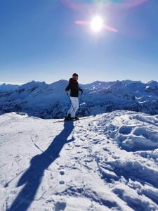 un hombre en esquís en la cima de una montaña cubierta de nieve en Appartement Haus Moser, en Sankt Michael im Lungau