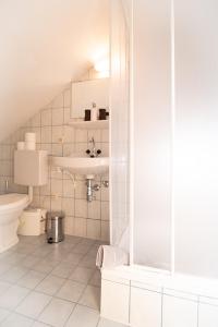 a white bathroom with a sink and a toilet at Appartement Haus Moser in Sankt Michael im Lungau