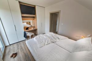 een slaapkamer met 2 witte bedden en een televisie bij Vila Vernig in Bled