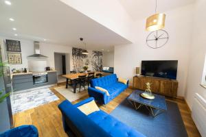 sala de estar con sofá azul y mesa en AppartUnique - Chez Helder, en Vichy