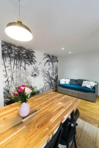 une salle à manger avec une table et un canapé dans l'établissement AppartUnique - Chez Helder, à Vichy
