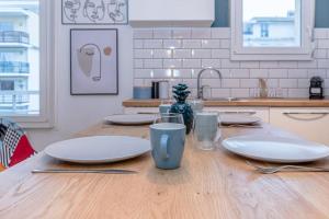 a wooden table with plates and glasses on top of it at L'impasse d'Or - Thionville, Metz, Luxembourg in Thionville
