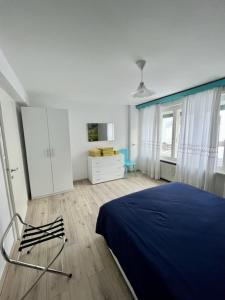 a bedroom with a blue bed and a dresser at SUITE DOLOMITI Appartamento in Falcade