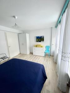 a bedroom with a blue bed and a blue chair at SUITE DOLOMITI Appartamento in Falcade