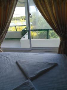 a bedroom with a bed and a large window at lake Edge Dambulla in Dambulla