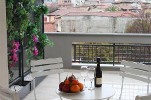 a table with a bottle of wine and a bowl of fruit at FILEO ELEGANT LIVING in Veria